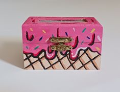 an ice cream box with pink icing and sprinkles painted on it