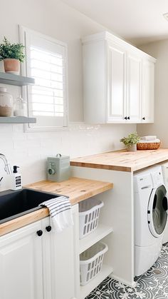 a washer and dryer sitting in a kitchen next to a counter with baskets on it