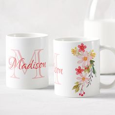 two personalized coffee mugs with flowers and the word madison on them are sitting next to each other