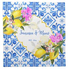 a blue and white tile with yellow lemons, pink flowers and leaves on it