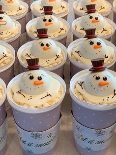 there are many cups with frosting in the shape of snowmen and faces on them