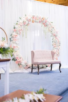 a chair sitting in front of a floral arch