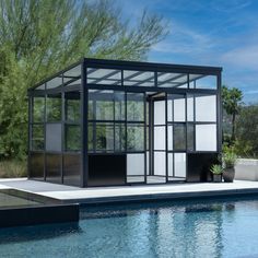 a glass house sitting on top of a swimming pool