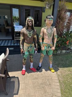 two men in costumes standing next to each other on a brick walkway outside a house