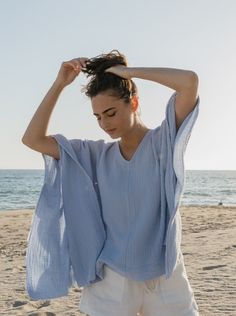 The perfect top to throw on with vintage Levi’s for running around town or doubles as an airy beach coverup. Made in a super soft cotton double gauze with raw edge trim. Takes you from beach to bar and from Summer to Fall. One Size Body length from shoulder 25.5” Body width flat 27” Delicate wash, tumble dry low *Raw edges are intentional on this garment. Please snip loose threads as necessary and wear with joy! Consciously made in small batches in sunny California using deadstock fabrics and re Relaxed Summer Tops With Frayed Hem, Breezy V-neck Tops For Beach, Relaxed Beach Cover-up Tops, Beachy V-neck Cover-up With Relaxed Fit, Spring Cotton Gauze Short Sleeve Tops, Spring Short Sleeve Cotton Gauze Tops, Breezy Cotton Cover-up For Vacation, Blue Breezy Beach Tops, Blue Breezy Top For Beach