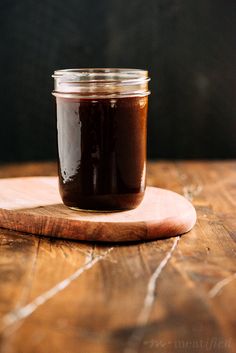 a jar of chocolate spread sitting on top of a wooden cutting board