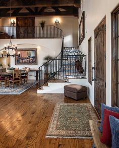 a living room filled with furniture next to a stair case and wooden floored stairs