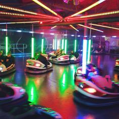 several people are riding bumper cars in an indoor ride - on area at the amusement park