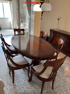 a dining room table with six chairs and a dresser in the corner next to it