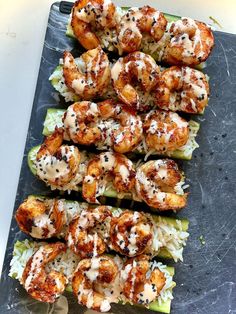 shrimp and rice kabobs are served on a platter with sauce drizzled over them