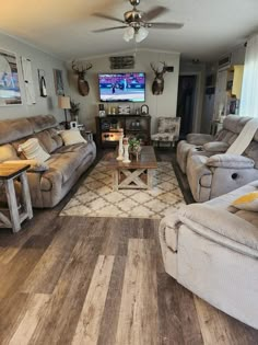 a living room filled with furniture and a flat screen tv mounted to the side of a wall