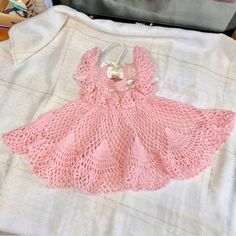 Super cute handmade by the private estate .... crochet dress.  Color is light pink with light green ribbon, white buttons and a white & pink bunny accent piece.  This is a vintage dress form the 1990's. My grandmother was a maker and made this dress for my future daughter....she hoped. I did have a daughter who wore but she never got to see it on her.   It was used a couple times.  Excellent condition but please do not expect it to be perfect.   No notable flaws I can see.  It has been packed away for over 22 years so it should be gently cleaned or professionally cleaned if you choose. Measurements are approximately --14 inches Shoulder to bottom --7 inches Pit to pit --3 inches Neck to neck I do not know the size in months or years as it was made at home by hand.   Please be sure to inspe Cute Lace Baptism Dress, Cute Handmade Pink Dress, Cute Handmade Dress For Baptism, Cute Hand Knitted Summer Dresses, Cute Pink Crochet Dress For Summer, Cute Pink Dress With Crochet Lace, Handmade Pink Crochet Dress In Cute Style, Cute Pink Crochet Dress, Pink Lace Dresses With Crochet Trim