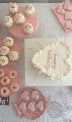 a table topped with cakes and cupcakes on top of plates