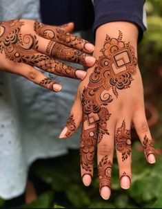 two hands with henna designs on them