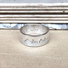 Two part interlocking hallmarked silver ring with matt and polished finishes based on your chosen city skyline. Makes a wonderful and unique keepsake of your honeymoon, special holiday or country of birth. Please specify a place name, and Hannah will work with you to create a silhouette before she starts making the ring. She can work from your own photograph if you have one of the panorama you would like or can source a suitable image with you. This ring is 8mm wide. Please ensure when selecting Cityscape Rings, Skyline Ring, Unique Silver Rings, Map Jewelry, Silver City, Place Names, Holiday Specials, City Skyline, Band Ring