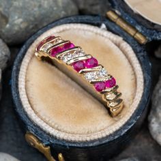 This prominent band features eight (8) round mixed cut rubies and six (6) round brilliant cut diamonds, channel set into seven (7) diagonal rows. The ring measures 4.5mm at the top, rises 3.0mm above the finger, tapering to 2.4mm wide and 1.0mm thick at the base of the shank. This ring is currently a size 6.75. Ruby Band Ring, Bands Rings, Ruby Bands, July Birthstone, Ruby Diamond, Channel Set, Ruby Ring, Vintage Diamond, Round Brilliant Cut Diamond