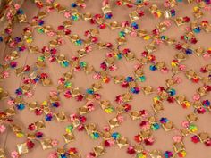 the fabric is covered with many different colored beads and sequins on top of it