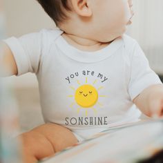 𝗬𝗢𝗨 𝗔𝗥𝗘 𝗠𝗬 𝗦𝗢𝗡𝗦𝗛𝗜𝗡𝗘 𝗦𝗛𝗜𝗥𝗧 The perfect gift for mom for her sonshine.  This cute take on sunshine by using SONshine instead makes the endearment for mom to son even sweeter! 𝗣𝗥𝗢𝗗𝗨𝗖𝗧 𝗠𝗔𝗞𝗘 𝗔𝗡𝗗 𝗗𝗘𝗦𝗜𝗚𝗡 𝗗𝗘𝗧𝗔𝗜𝗟 These jersey short sleeve tee fits like a well-loved favorite. Soft cotton and quality print make users fall in love with it over and over again. These t-shirts have-ribbed knit collars to bolster shaping. The shoulders are tapered for a better fit over time. Dual side seams hold the garment's shape for longer.  .: Made with 100% Airlume combed and ring-spun cotton, a lightweight fabric that is easy to layer, and breathable. Perfect for active and leisure wear.  .: The retail fit that is perfect for casual and semi-formal settings. The crew ne Little Boy Shirts, Mom To Son, Boy Onesies, Jersey Tshirt, Baby Boy Onesies, Boy Onesie, My Sunshine, Perfect Gift For Mom, You Are My Sunshine