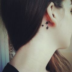 a woman with black stars on her left ear