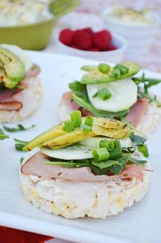 two sandwiches with ham, cucumbers and lettuce on them