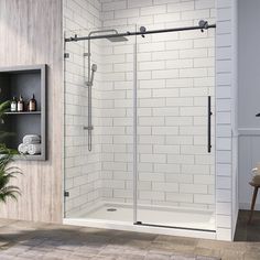 a white tiled bathroom with a glass shower door and shelves on the wall next to it