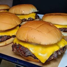 four cheeseburgers sitting on top of a table