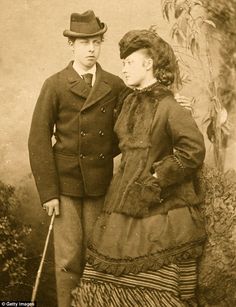 an old photo of two people standing next to each other