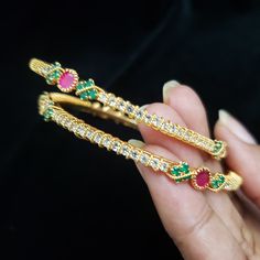 "* Handcrafted Gold Plated bracelet. * Bangles with pretty CZ stones * High Quality 22 K Gold Plated bracelet. Bangles Sizes : 2.4 ( 2.30\" diameter of the inner circle) ; 2.6 ( 2.46\" diameter of the inner circle); 2.8 (2.54\" diameter of the inner circle) The Gorgeous gold-plated bangle/ bracelet best exemplifies the careful craftsmanship done on it -- a specialty at Nemali Jewelry. It has a special tone of elegance attached to it. The intricate handmade design of the bangle/bracelet set gives Jeweled Crystal Bangle Bracelet, Jeweled Round Crystal Bracelet For Gift, Jeweled Crystal Bracelet Gift, Gold Bangle With Stones, Stones Bangle For Gift, Stones Bangle Gift, Jeweled Round Crystal Bracelet As Gift, Round Stone Bangle As Gift, Traditional Festive Gemstone Bangle