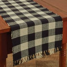 a black and white checkered table runner on top of a wooden dining room table