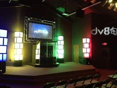 the stage is set up for an event with lights on it and a projector screen