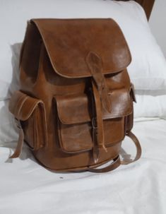 Moroccan leather backpack, good quality, handmade Genuine leather.perfect for work or school or travel. Our leather bags are handmade by highly skilled artisans in a small leather workshop in the old medina. This 100% organic backpack is unique, plain, simple and soft, designed to highlight the natural beauty of leather. The bag has 5 pockets can be carried casually on the hand, shoulder or carried as a backpack. It can be used at school, while traveling or in any other activity. Finely handcraf Leather-lined Backpack Satchel For Daily Use, Leather Shoulder Backpack For Daily Use, Daily Use Satchel Backpack With Leather Lining, Leather Backpack With Rectangular Shape, Leather Satchel For Trip, Leather Backpack With Large Capacity, Leather Laptop Bag With Large Capacity, Large Capacity Leather Duffle Bag Backpack, Vintage Leather Backpack-style Shoulder Bag