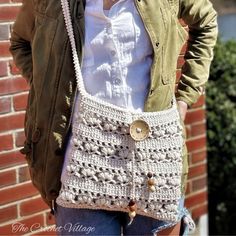 a woman is holding a crocheted purse