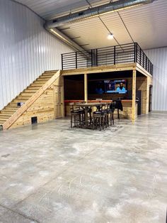 the inside of a building with tables and chairs in front of a television set on a wall