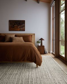 a large bed in a bedroom next to a window with lots of light on it