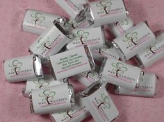 a bunch of small white candy bars sitting on top of a pink tablecloth covered floor