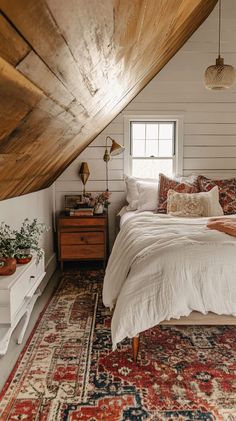 Cozy boho attic bedroom with slanted wooden ceiling, colorful rug, vintage furniture, and natural light. Bedroom With Slanted Ceiling Ideas, Boho Attic Bedroom, Loft Bedroom Ideas Sloped Ceiling, Slanted Ceiling Bedroom Ideas, Cabin Loft Bedroom, Attic Space Ideas, Cozy Attic Bedroom