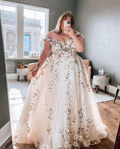 a woman taking a selfie in her wedding dress while standing in front of a mirror