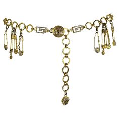 Presenting an extremely rare gold-tone Gianni Versace safety pin chain belt designed by Gianni Versace. From the Spring/Summer 1994 collection, this rhinestone accented belt debuted on the season's runway as part of Look 82, modeled by Christy Turlington Burns. This belt features a Greek key chain and is complete with clusters of gold safety pins. The safety pin, a Versace house code, was made infamous when worn by Elizabeth Hurley and has been reused in more recent collections by Donatella. If Versace Chain Belt, Luxury Gold-tone Metal Chain Belt, Luxury Gold Metal Chain Belt, Versace House, Versace Safety Pin, Medusa Versace, Versace Chain, Gold Chain Belt, Belt Chain