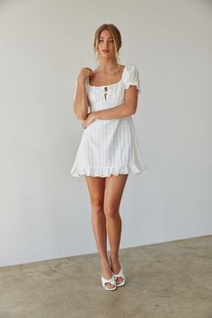 Prepare to blossom in the Clover Puff Sleeve Gingham Mini Dress this Spring Summer! This babydoll mini dress is ready for sunny days and daydreaming; featuring darling puff sleeves, an open back silhouette, tie front bustier detail. Available in white and sage green with a subtle gingham print. Pair this sundress with a pair of cowboy boots to complete the outfit! Details Shell: 100% Cotton Lining:100% Polyester Back zipper and button up closure Elastic sleeves Partially lined Hand Wash Cold Puff Sleeve Mini Dress With Ruffles For Picnic, White Smocked Bodice Mini Dress For Garden Party, White Mini Dress With Smocked Bodice For Garden Party, White Puff Sleeve Mini Dress With Smocked Back, White Puff Sleeve Dress With Tie Back For Brunch, White Square Neck Mini Dress For Picnic, White Mini Dress With Square Neck For Picnic, Cute White Puff Sleeve Dress For Brunch, Back Silhouette