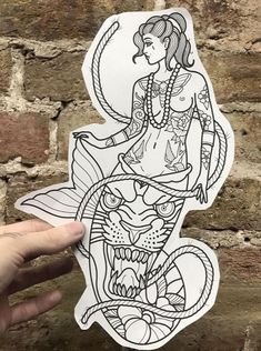 a hand holding up a sticker with an image of a woman sitting on top of a