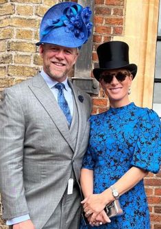 a man in a suit and tie standing next to a woman wearing a blue dress