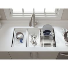 a kitchen sink filled with dishes and utensils next to a faucet