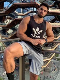 a man sitting on top of a metal railing