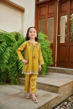 2-Piece Embroidered Suit for Girls (shirt & trouser only) : A classic Intricately crafted design and captivating details make this two-piece staple a perfect style statement for you and your little one. Description -- Kameez (Shirt) : Paper Cotton shirt engraved with floral embroidered details and mirror embellishment. Lining included. -- Shalwar (Trouser) : Green Pants. General Care Instruction : Should be hand washed and hung to dry. Color may bleed so please be mindful of other items with it. Festive Cotton Pant Set With Floral Embroidery, Cotton Pant Set With Floral Embroidery For Eid, Floral Embroidery Cotton Pant Set For Eid, Cotton Pant Set With Floral Embroidery For Diwali, Diwali Cotton Pant Set With Floral Embroidery, Festive Yellow Sets With Embroidered Border, Yellow Long Sleeve Pant Set For Festive Season, Festive Sets With Dabka Work For Spring, Festive Spring Sets With Dabka Work