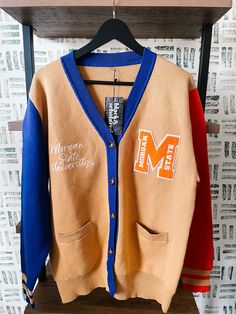 Make a bold statement and wear your Morgan State pride with this one-of-a-kind and comfortable cardigan sweater, perfect for any alumni, students or supporters. Made with the highest quality materials, this sweater is designed to keep you warm and cozy while representing Morgan State. Features:- Official Morgan State University logo embroidered on the chest- Large "M" Chenille patch- Classic cardigan design with a tortoise shell button-up front- Two front pockets (deep enough to fit a phone and Morgan State University Decision Day, Collegiate Sweater For Game Day In Fall, Collegiate Fall Sweater For Game Day, Collegiate Style Sweater For Game Day In Fall, Fall College Cardigan With Ribbed Cuffs, Winter Campus Sweater With Ribbed Cuffs, Winter Cardigan For College, Fall Sweater For College, College Style Sweater For Fall Season