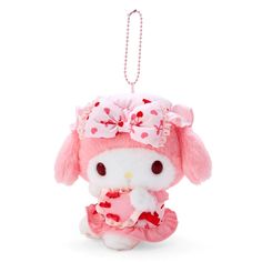 a pink and white stuffed animal with a bow on it's head sitting next to a key chain