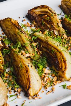 grilled artichokes with herbs and nuts on a white plate