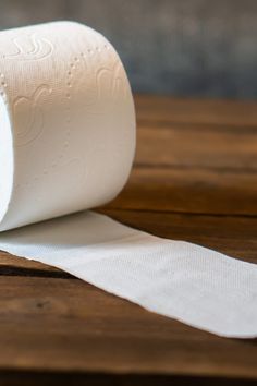 a roll of toilet paper sitting on top of a wooden table