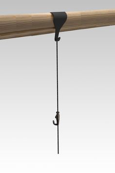 a wooden rail with an iron hook attached to the top and two black hooks hanging from it