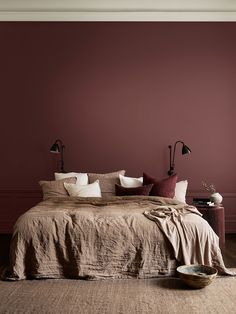 a large bed sitting in a bedroom next to a wall with red paint on it